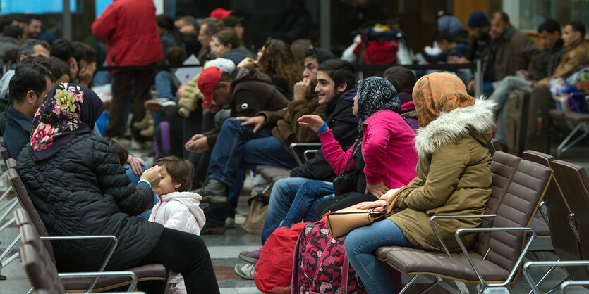 Menschen sitzen auf Bänken und unterhalten sich