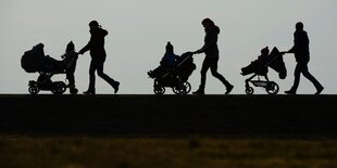 Kinderwagen werden geschoben.