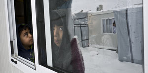 Kinder stehen an einem Fenster