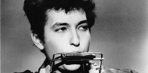 Der junge Bob Dylan bläst auf einer Mundharmonika