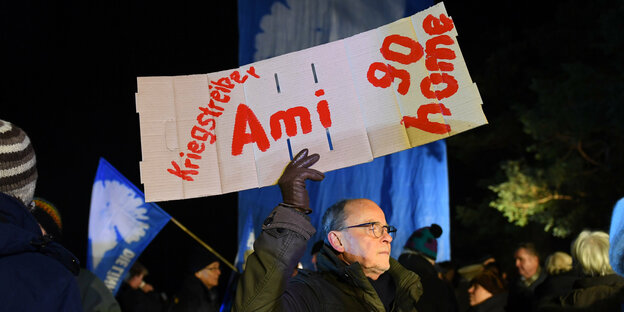 Demonstrant mit Schild: "Ami go home"