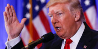 Donald Trump auf der Pressekonferenz strecht die Hand in die Luft