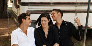 Jamie Smith, Romy Madley Croft und Oliver Sim von The xx auf einer Schaukel