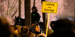 ein Demonstrant häte ein Schild, auf dem steht „Leipzig zeigt Courage“