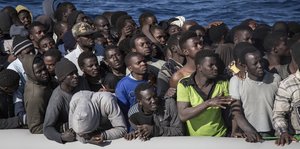 Viele schwarze Menschen in einem Schlauchboot