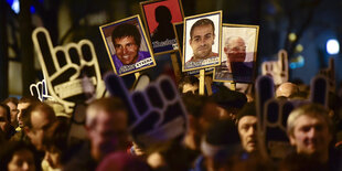 Demonstranten halten Fotos hoch