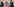 Zwei Männer in Anzügen stehen sich in einem Büro gegenüber, zwischen ihnen ein Schreibtisch, an der Wand viele eingerahmte Bilder