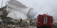 Ein Feuerwehrmann durchsucht die Trümmer eines Flugzeugs