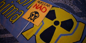 Auf einem Transparent ist ein Atomkraftsymbol in Form von Munchs „Schrei“ zu sehen, daneben steht „Nuclear Nao“