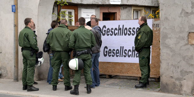 Polizisten stehen vor dem Haus des NPD-Bundesparteitags: Geschlossene Gesellschaft steht auf der geschlossenen Pforte