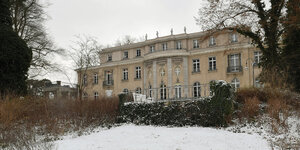 Die Gedenk- und Bildungsstätte Haus der Wannsee-Konferenz erhebt sich zwischen kahlen Bäumen und verschneiten Wiesen