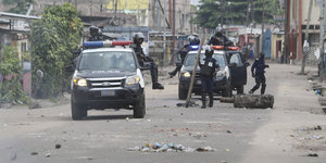 Polizisten entfernen eine Straßenblockade in Kinshasa