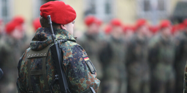 Bundeswehrsoldaten mit rotem Barett und geschulterter Waffe