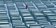 Auf dem Stelenfeld des Holocaust-Mahnmals liegt Schnee. Eine Frau mit einer roten Jacke läuft zwischen den Steinen