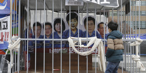 In einem Käfig sind Pappfiguren von Park Geun Hye und ihren Helfern zu sehen