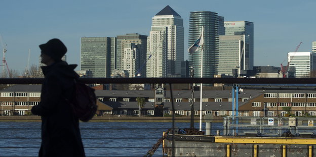 Im Hintergrund die Londoner Sykline, im Vordergrund das Profil einer Frau mit Hut