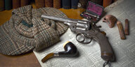 Die Utensilien von Sherlock Holmes: Revolver, Pfeife, falsche Nase, Schiebermütze und Spritzbesteck