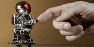 Ein Roboter berührt den Finger einer ausgestreckten menschlichen Hand