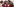 Eine Frau in weiß-roter Kleidung im Vordergrund, weitere Menschen in denselben Farben im Hintergrund