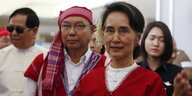 Eine Frau in weiß-roter Kleidung im Vordergrund, weitere Menschen in denselben Farben im Hintergrund