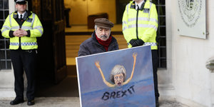 Der Maler Kaya Mar mit dem Bild der ertrinkenden Premierministerin Theresa May vor dem Gebäude des Supreme Court in London
