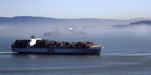Ein Conainerschiff. Im Hintergrund San Francisco