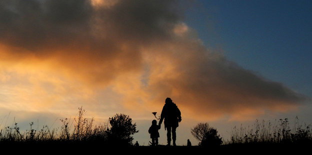 Eine Frau und ein Kind laufen in den Sonnenuntergang