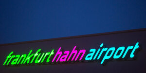 Bunt beleuchteter Schriftzug des Flughafen im Dunkeln