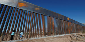 Zwei Kinder stehen am Grenzzaun zwischen Mexiko und den USA