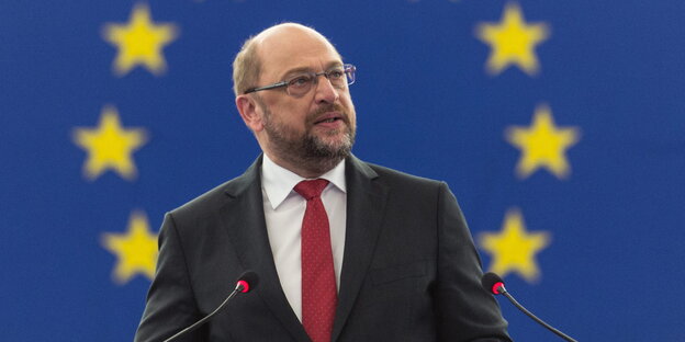 Martin Schulz vor einer blauen Wand mit gelben Sternen