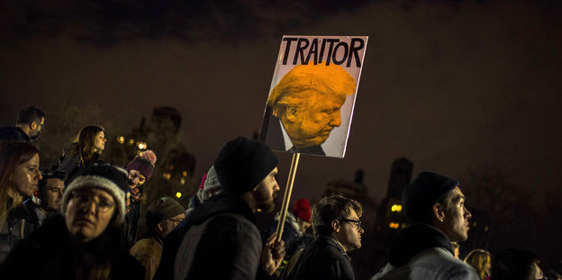 Traitor, also Verräter steht auf einem Schild, das Demonstranten durch New York tragen