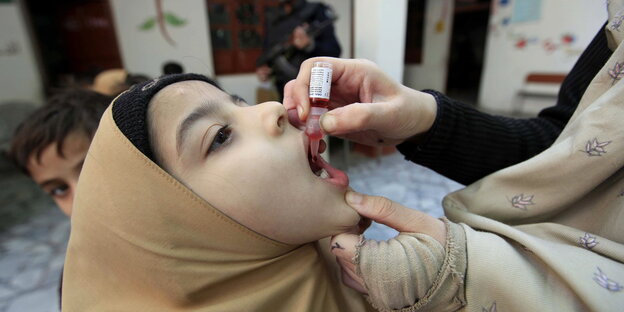 Ein Kind bekommt die Impfflüssigkeit verabreicht