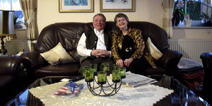 Ein älteres Ehepaar sitzt auf einem Sofa