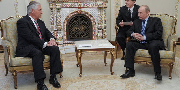 Rex Tillerson und Vladimir Putin sitzen vor einem Kamin