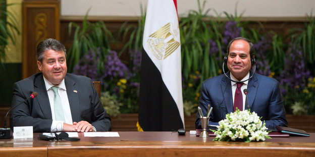 Sigmar Gabriel sitzt neben Ägyptens Präsident Al-Sisi an einem Tisch, zwischen ihnen eine Fahne