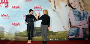 Zwei Frauen vor einem riesigen Filmplakat mit Mädchen und Pferd