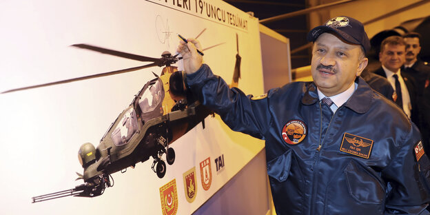 Der türkische Verteidigungsminister Firki Isik vor einem Plakat mit einem Helikopter