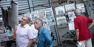 Griechische Männer lesen Zeitungen an einem Straßenstand