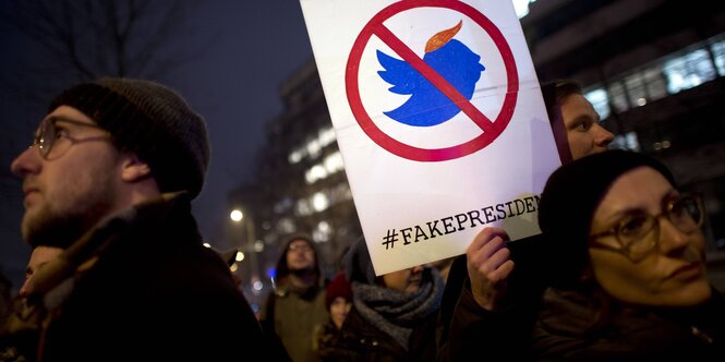 Demonstraten mit einem Schild, auf dem Fakepresident steht