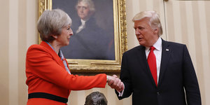 Trump und May schütteln sich die Hand vor einem Gemälde
