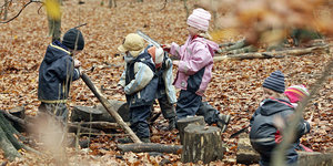 Kinder spielen in einem herbstlichen Wald