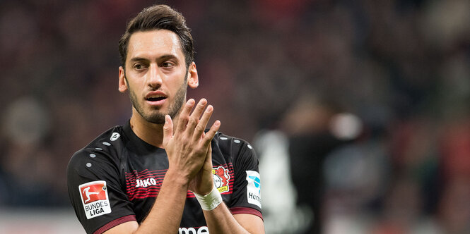 Der Fußballer Hakan Çalhanoğlu im Trikot von Bayer Leverkusen klatscht in die Hände