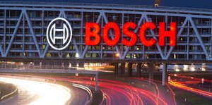Das Logo von Bosch hängt über eine Straße, die Lichter der Autos sind dank Langzeitbelichtung nur Schlieren