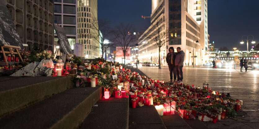 Blumen und Kerzen auf Stufen vor einem Gebäude