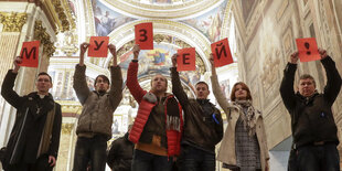 Menschen in einer Kirche heben Zettel hoch