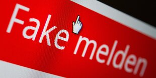 Ein Computerbildschirm mit der Aufschrift "Fake melden" in weiß auf rotem Grund, darüber ein Mauszeiger