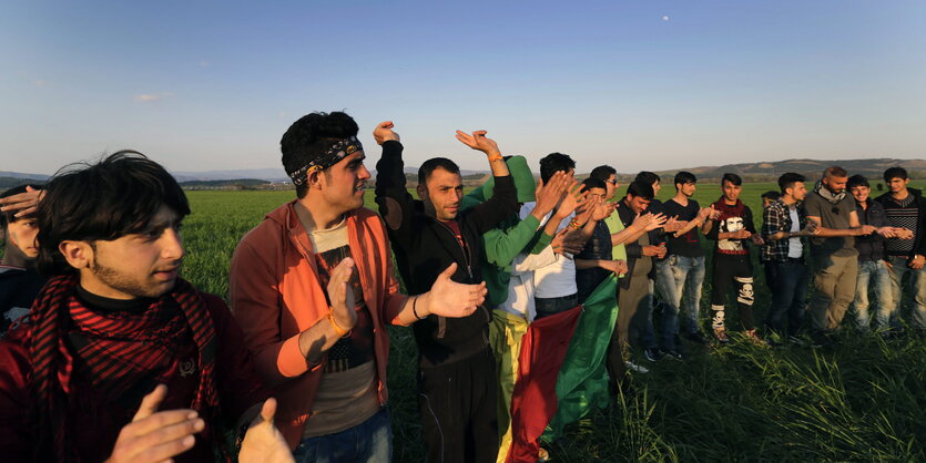 Männer stehen auf einem Feld und klatschen in die Hände