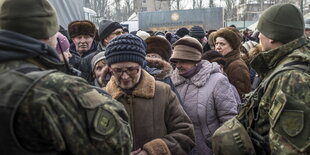 Einwohner von Awdiiwka stehen am humanitären Hilfecenter Schlange, um Essen zu bekommen und sich aufzuwärmen