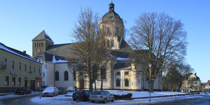 Bild eines städtischen Platzes. Zu sehen sind ein Wirtshaus und eine Kirche