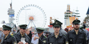 Polizistinnen und Polizisten nebeneinander, dahinter Oktoberfest